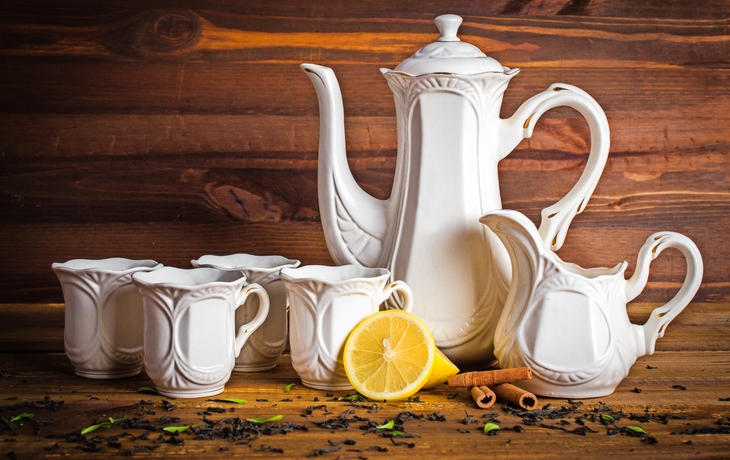 Weißer Tee-Set. Zitrone, Zimt und losem Tee. Auf einem hölzernen Hintergrund.